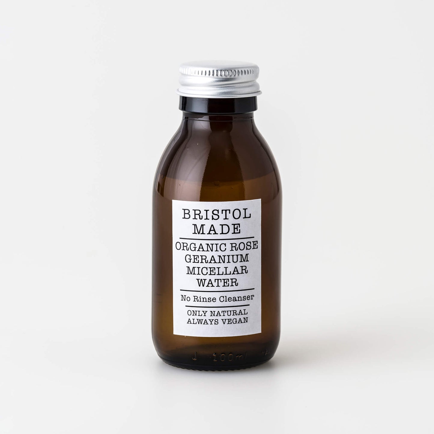 A 100ml bottle of Bristolmade rose geranium Micellar Water, featuring an opaque liquidwith a white label and black text, made with natural ingredients for gentle cleansing and makeup removal.